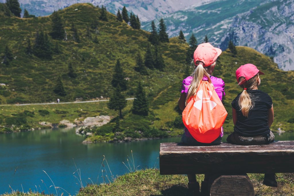 https://www.pexels.com/photo/two-girls-sitting-on-brown-bench-near-body-of-water-1292006/